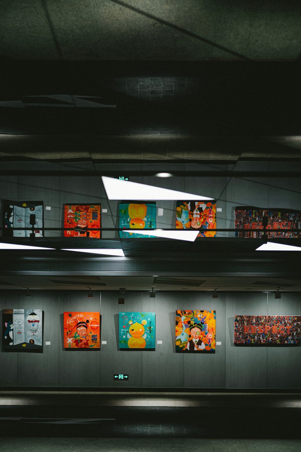 Barevné pop-artové malby na galerijní stěně.